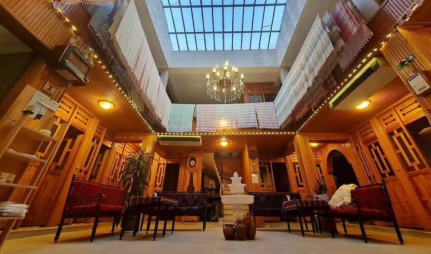 Я роздивляюся інтер'єр історичного готелю Pera Palace у Стамбулі у стилі Belle Époque з різьбленими дерев'яними балконами, кришталевими люстрами та скляним дахом.