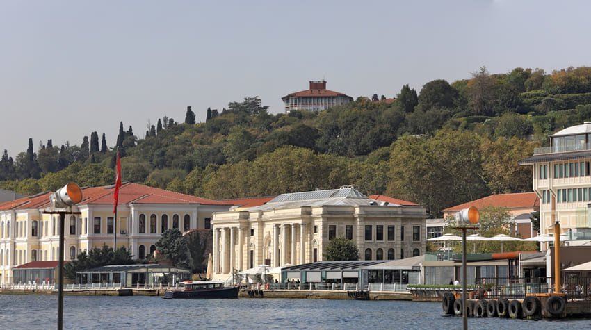 Вид з Босфору на історичні палаци та розкішні готелі на набережній Бешікташа в Стамбулі, із зеленим парком Їлдиз на задньому плані.