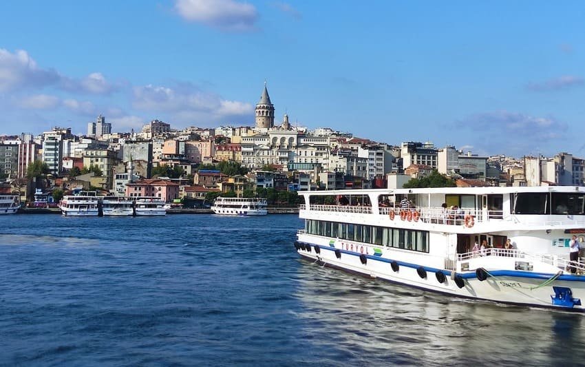 Пором, що пливе по Босфору з чітким видом на Галатську вежу та будівлі району Каракей у Стамбулі.